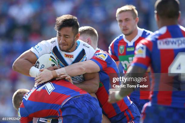 Nathaniel Peteru of the Titans is tackled by the Knights defence during the round two NRL match between the Newcastle Knights and the Gold Coast...