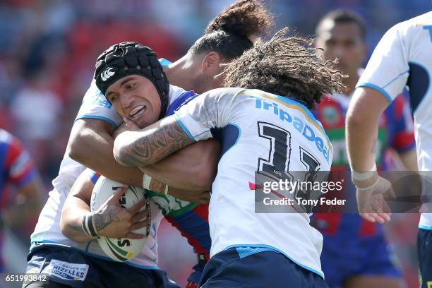 Sione Mata'Utia of the Knights is tackled by the Titans defence during the round two NRL match between the Newcastle Knights and the Gold Coast...
