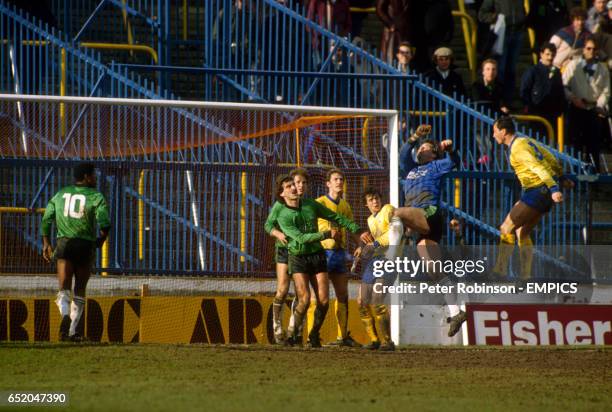 Plymouth Argyle goalkeeper Geoff Crudgington punches the ball away from Oxford United's Bobby McDonald , watched by teammates Mark Chamberlain and...