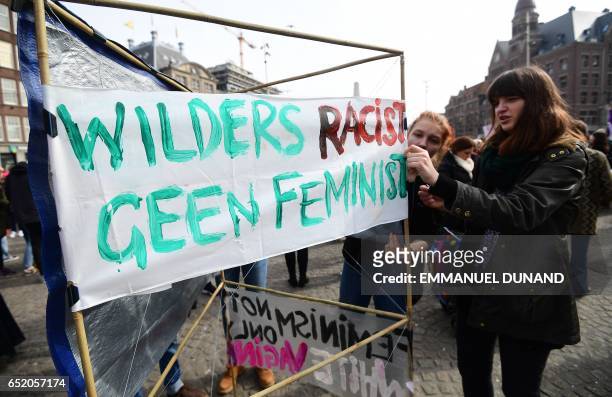 Woman sets up a sign against Dutch far-right candidate Geert Wilders as she takes part in the "Womens March for a united Netherlands" calling for...