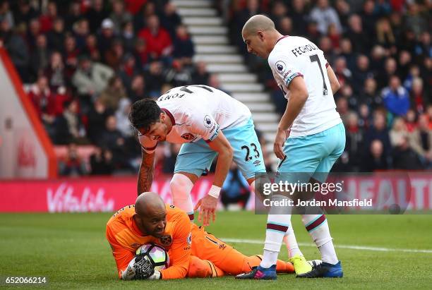 Darren Randolph of West Ham United is congraulated by Jose Fonte of West Ham United and Sofiane Feghouli of West Ham United are saving Benik Afobe of...