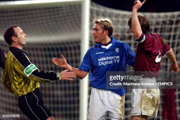 Referee Mark McCurry runs over to calm a situation between Rangers' Fernando Ricksen and Heart Of Midlothian's Steven Pressley