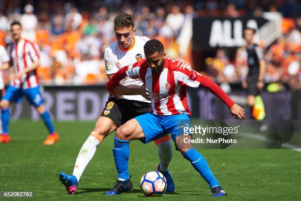 Munir El Haddadi of Valencia CF and Douglas Pereira Dos Santos of Real Sporting de Gijon during their La Liga match between Valencia CF and Real...