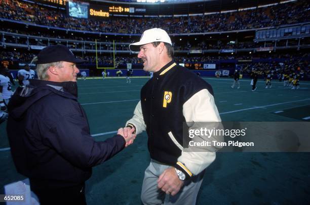 Head Coach Bill Cowher of the Pittsburgh Steelers shakes hands with Head Coach Jon Gruden of the Oakland Raiders at the Three Rivers Stadium in...