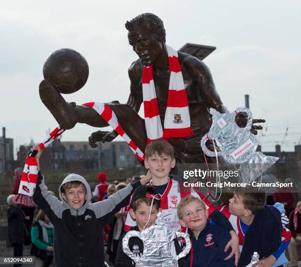 Young Lincoln City fans decorate the Dennis Bergkamp statue with their sides colours ahead of the Emirates FA Cup Quarter-Final match between Arsenal...