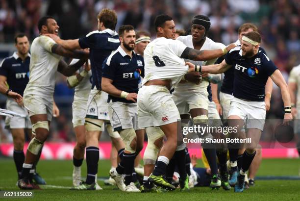 Nathan Hughes of England and Finn Russell of Scotland confront each other while Maro Itoje of England attempts to get in between them during the RBS...