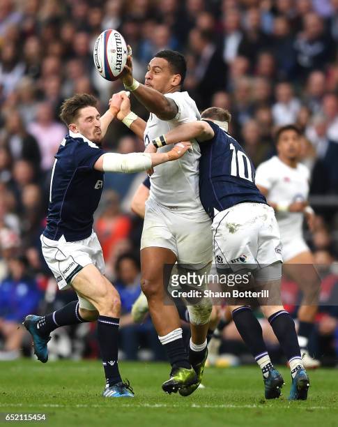 Nathan Hughes of England stretches to collect the ball while Finn Russell of Scotland takcles him during the RBS Six Nations match between England...