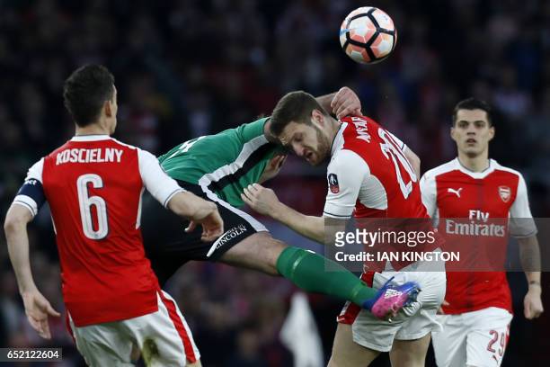 Arsenal's German defender Shkodran Mustafi is hurt in this clash with Lincoln City's English striker Matt Rhead during the English FA cup quarter...