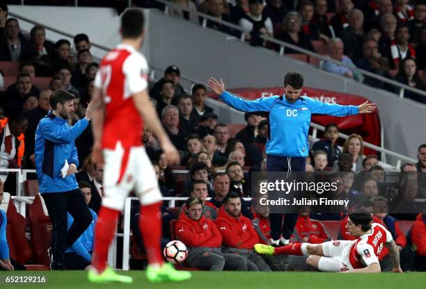 Danny Cowley manager of Lincoln City evades a sliding Hector Bellerin of Arsenal during The Emirates FA Cup Quarter-Final match between Arsenal and...