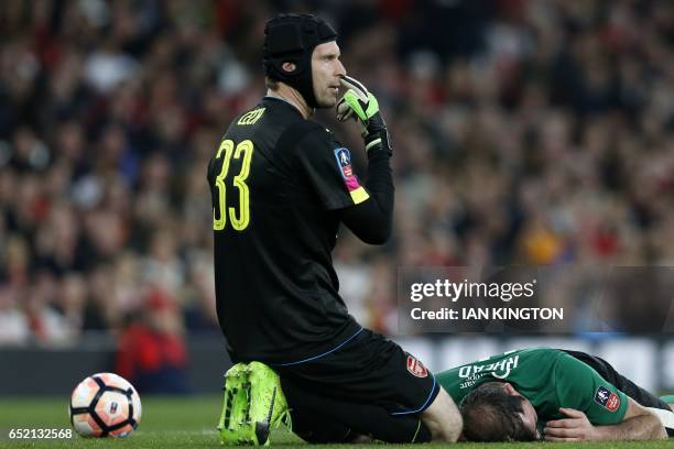 Arsenal's Czech goalkeeper Petr Cech gestures to the officials as Lincoln City's English striker Matt Rhead lies injured during the English FA cup...