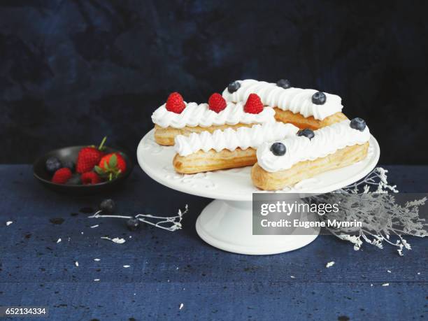 eclairs with whipped cream and berries - eclairs stock pictures, royalty-free photos & images