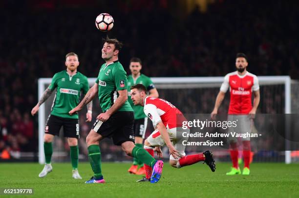 Lincoln City's Matt Rhead heads forward under pressure from Arsenal's Aaron Ramsey during the Emirates FA Cup Quarter-Final match between Arsenal and...