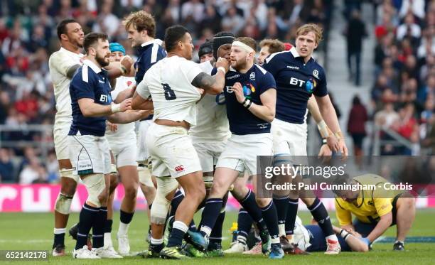 Scotland team mates get heavy handed with Nathan Hughs of England over a heavy tackle while England's Courtney Lawes renews his conflict with Richie...