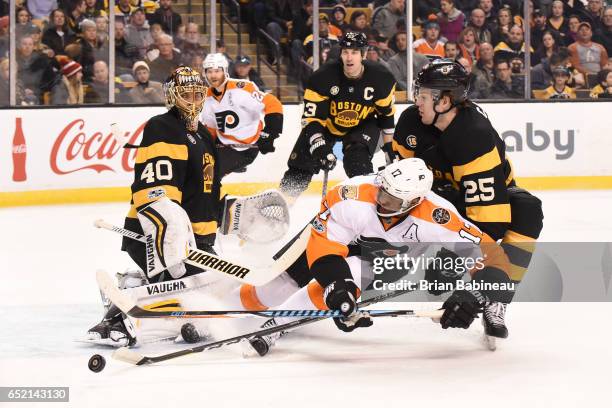 Wayne Simmonds of the Philadelphia Flyers fights for the puck against Brandon Calro of the Boston Bruins at the TD Garden on March 11, 2017 in...