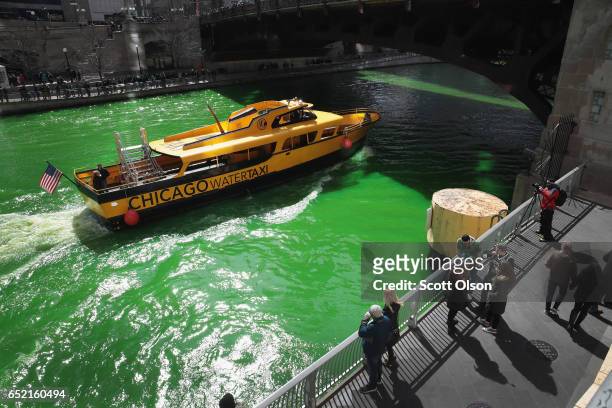 Water taxi navigates the Chicago River shortly after it was dyed green in celebration of St. Patrick's Day on March 11, 2017 in Chicago, Illinois....
