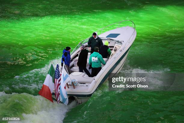 Workers use a boat to mix dye into the Chicago River to turn it green in celebration of St. Patrick's Day on March 11, 2017 in Chicago, Illinois....