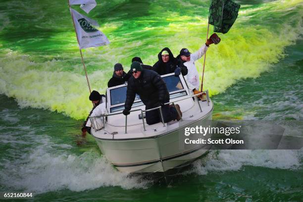 Workers use a boat to mix dye into the Chicago River to turn it green in celebration of St. Patrick's Day on March 11, 2017 in Chicago, Illinois....