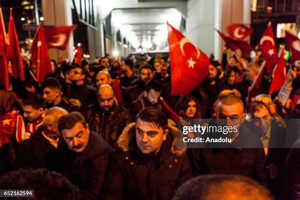 Turkish people hold flags as Turkish family minister's vehicle was intercepted by Dutch police 30 meters close to the Consulate General's residence...