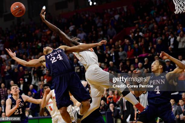 Myles Stephens of the Princeton Tigers and Matt Howard stretch for the ball as Darnell Foreman of the Pennsylvania Quakers looks on during the second...