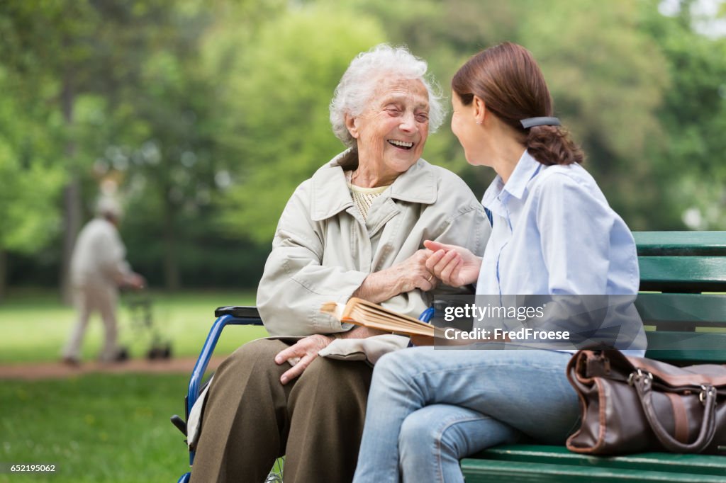 Senior woman with caregiver in the park