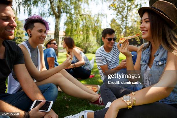 vrienden eten pizza buiten - campus party stockfoto's en -beelden