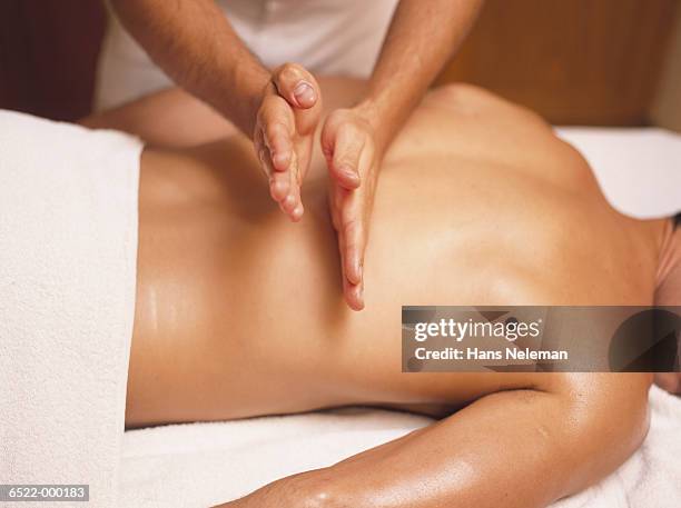 hands massaging man's back - spa treatment stock pictures, royalty-free photos & images