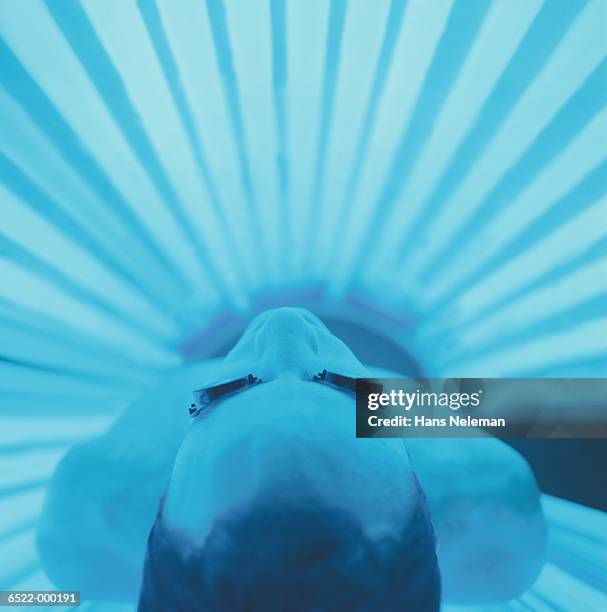 man on tanning bed - zonnebank stockfoto's en -beelden