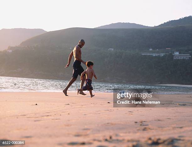 father and son playing soccer - brazilian playing football stock-fotos und bilder