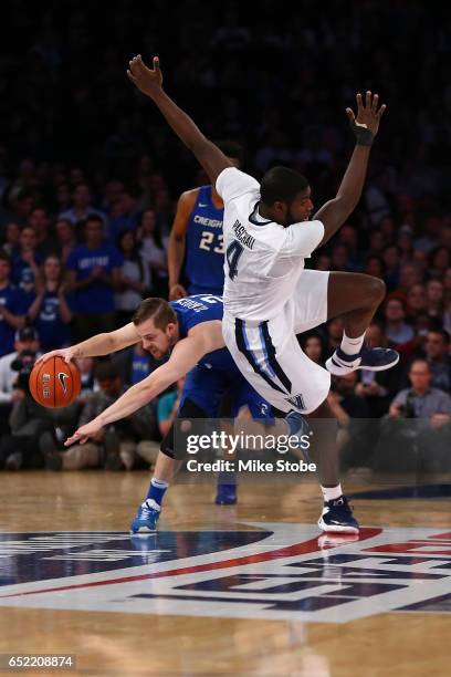 Eric Paschall of the Villanova Wildcats trips up over Isaiah Zierden of the Creighton Bluejays during the Big East Basketball Tournament -...