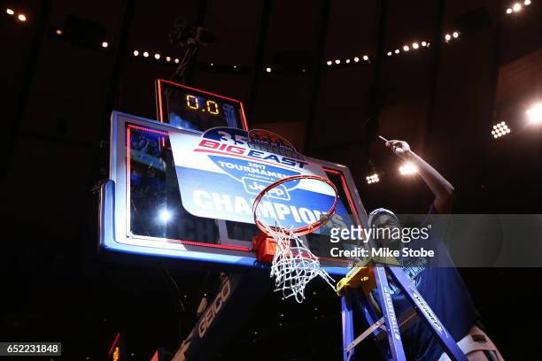 Kris Jenkins of the Villanova Wildcats cuts a piece of the net after defeating the Creighton Bluejays to win the Big East Basketball Tournament -...