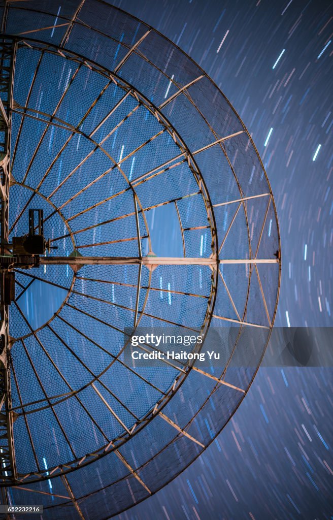 Star trails over a radio telescope antenna