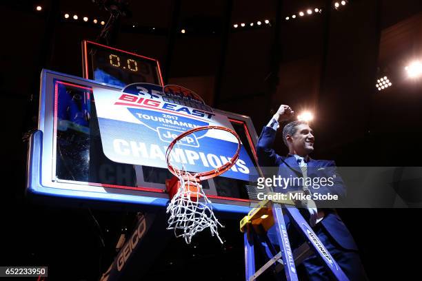 Head coach Jay Wright of the Villanova Wildcats cuts a piece of the net after defeating the Creighton Bluejays to win the Big East Basketball...