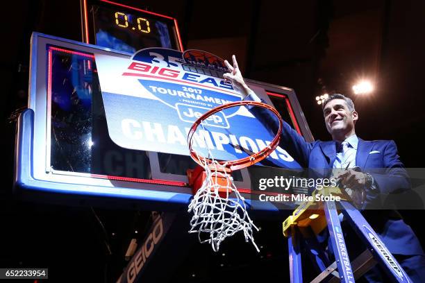 Head coach Jay Wright of the Villanova Wildcats cuts a piece of the net after defeating the Creighton Bluejays to win the Big East Basketball...