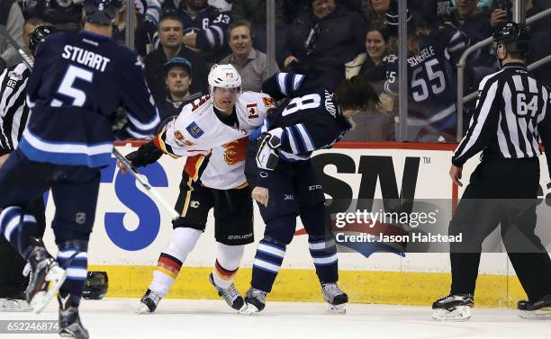 Jacob Trouba of the Winnipeg Jets fights Sam Bennett of the Calgary Flames during NHL action on March 11, 2017 at the MTS Centre in Winnipeg,...