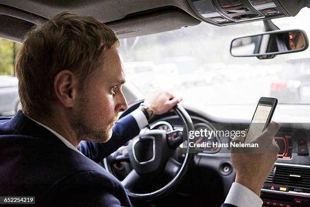 man using gps device while driving - car interior side stock pictures, royalty-free photos & images