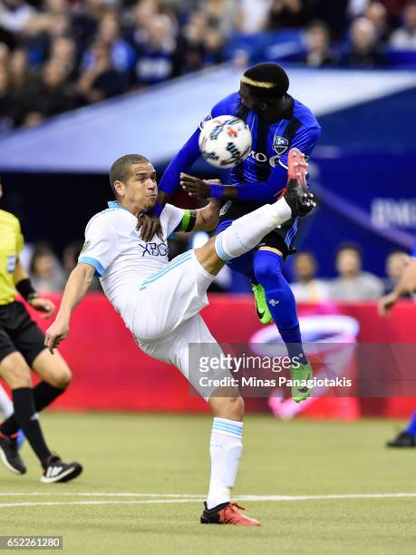 March 11: Osvaldo Alonso of the Seattle Sounders kicks the ball as Ambroise Oyongo of the Montreal Impact jumps in the air for a block during the MLS...