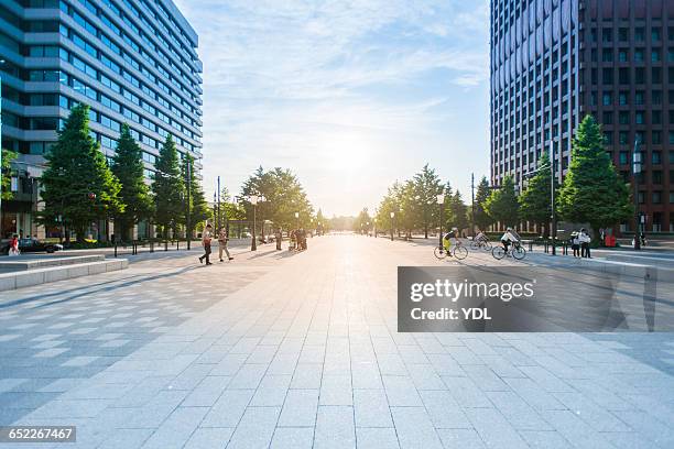 crossing people and bike on boulevard. - tokyo financial district stock pictures, royalty-free photos & images