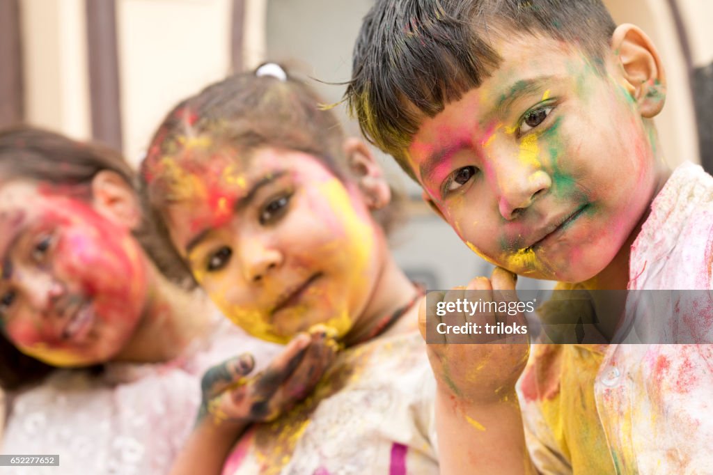 Three little kid celebrating holi