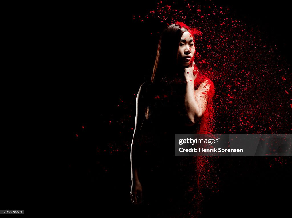 Young woman sprayed by red powder