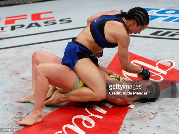 Marion Reneau punches Bethe Correia of Brazil in their women's bantamweight bout during the UFC Fight Night event at CFO - Centro de Formaco...