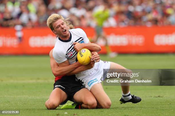 George Horlin-Smith of the Cats is tackled during the JLT Community Series AFL match between the Geelong Cats and the Essendon Bombers at Queen...