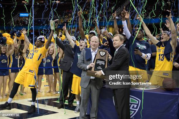 Mid American Conference commissioner Dr. Jon Steinbrecher presents Kent State Golden Flashes head coach Rob Senderoff with the MAC Tournament trophy...