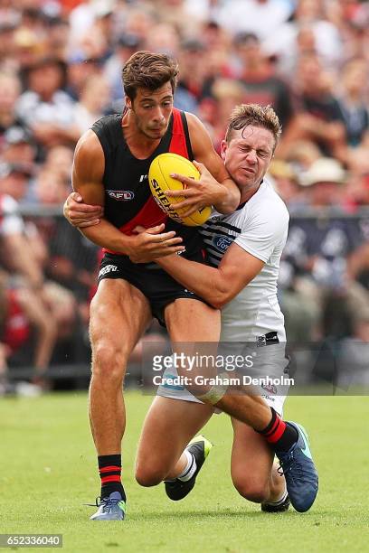 Kyle Langford of the Bombers is tackled by Mitch Duncan of the Cats during the JLT Community Series AFL match between the Geelong Cats and the...