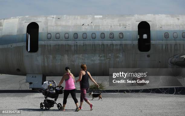 Family members of United Nations peacekeepers jog past a decaying and abandoned passenger plane of Cyprus Airways at Nicosia International Airport...