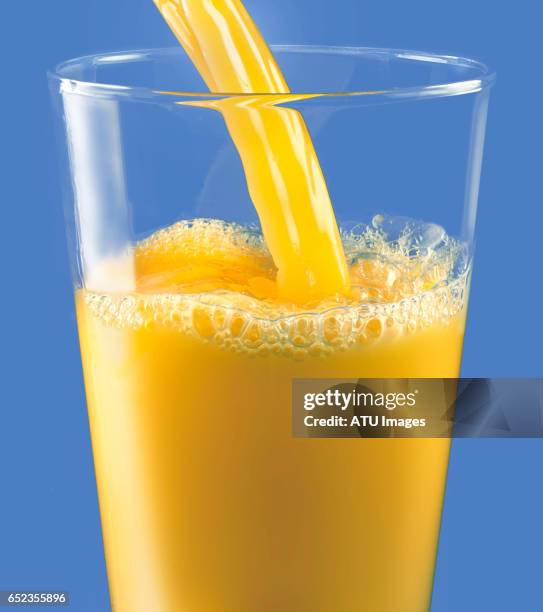 orange juice on blue - orange juice stock pictures, royalty-free photos & images