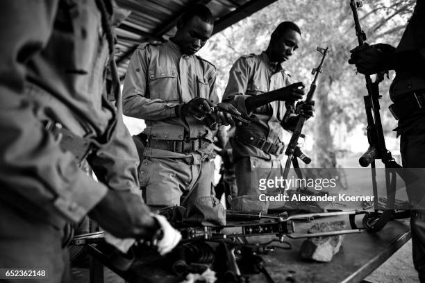 Soldiers of the Malian Armed Forces clean their AK47 rifle after shooting with live ammunition at the shooting range at a training base on March 09...