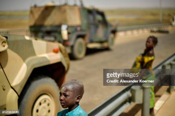Small boy and his sister watche soldiers of the Bundeswehr, the German Armed Forces, on the bridge of the river Niger after leaving a weekly cattle...