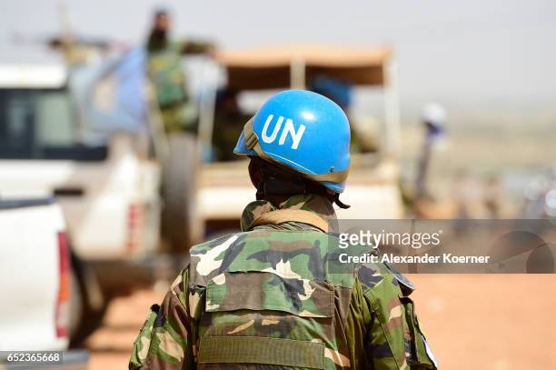 Bangladeshi United Nations soldier walks by a car during the weekly cattle market on March 7, 2017 in Gao, Mali. Each week locals and Touareg nomads...