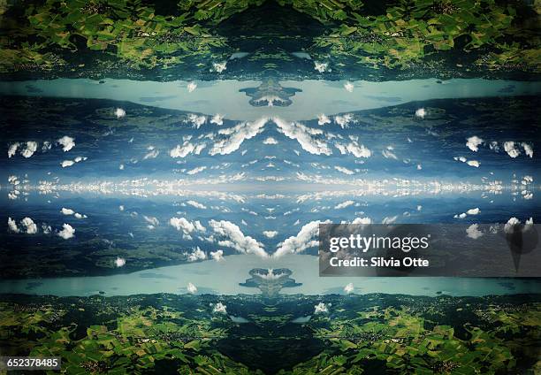 cumulus clouds above surreal landscape and lake - kaleidoscope stock-fotos und bilder