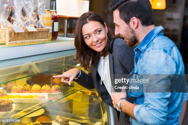 middle aged woman and young manl looking at display window - buffet display stock pictures, royalty-free photos & images